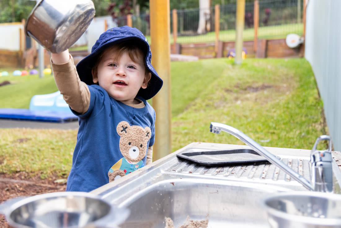 A child playing at the outdoor water station